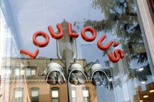Logo on a glace panel part of Loulou's restaurant branding and visual identity | CRA Graphic Design